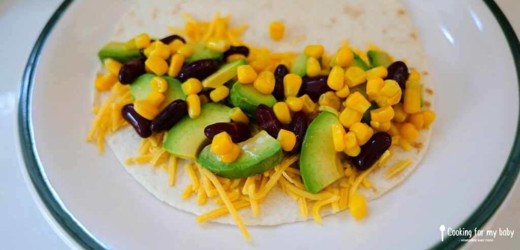 Avocat, haricots rouges, maïs et cheddar dans une tortilla pour les quesadillas de bébé